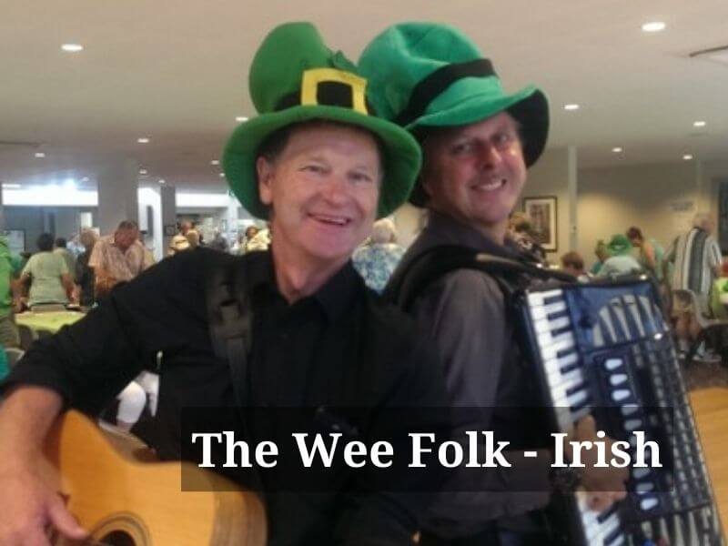 Male accordionist and guitarist  with Irish style hats smiling 